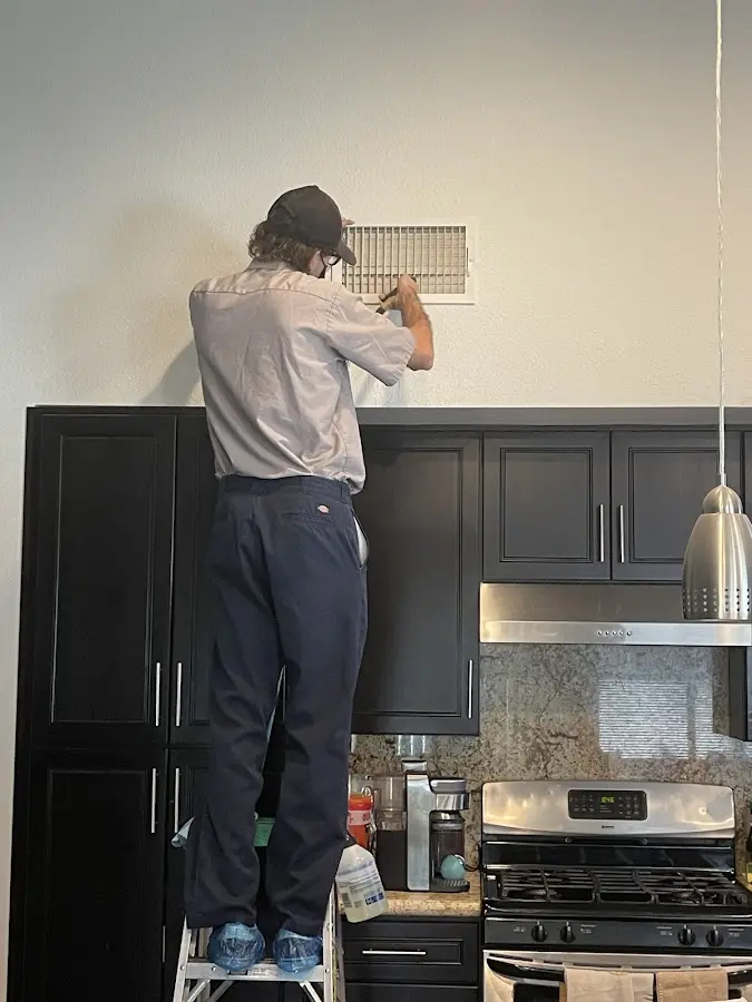 Technician inspecting an air vent during HVAC service in Morton Grove